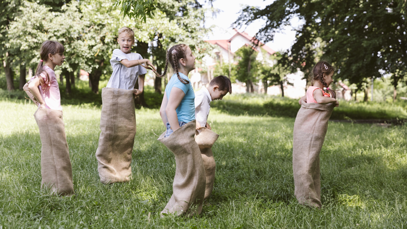 Niños jugando carreras de sacos